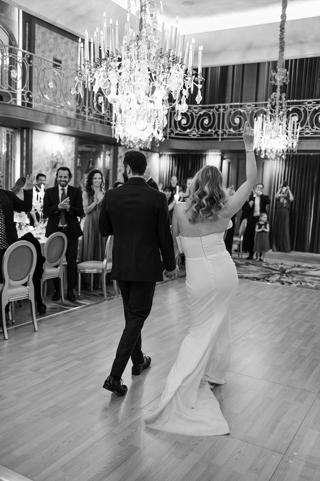 Newlyweds arriving in the Plaza Athénée reception room with guests gathered around